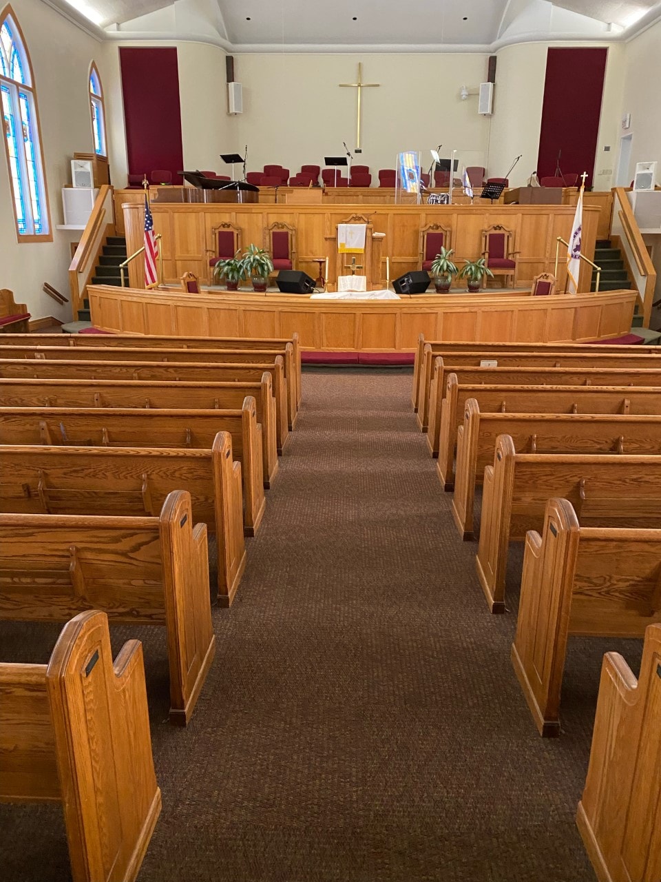 Traditional sanctuary with wooden pews and burgundy carpet aisle