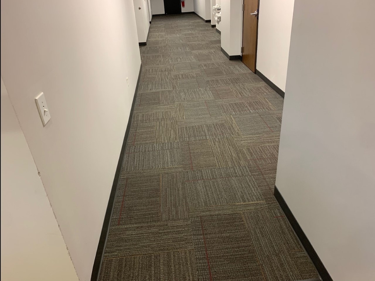Commercial office hallway with grey and brown carpet tile
